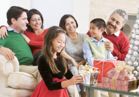 Family Sitting On Sofa In Front Of Christmas Presents